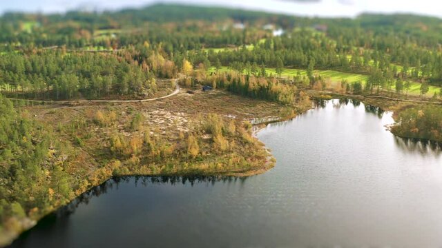 Cinematic aerial footage over colorful green golf course and Northern Sweden autumn landscape. North of Sweden. Cinema tilt shift effect, vibrant colors, drone footage.
