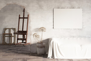 An artist's workshop with a blank horizontal poster over a covered sofa, dried flowers in a shabby clay pot, an arched doorway, an easel with pictures and frames in the background.Front view.