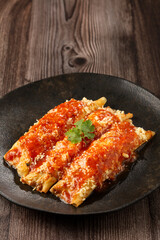 Pancakes stuffed with minced meat and topped with tomato sauce and grated cheese.