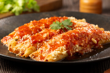 Pancakes stuffed with minced meat and topped with tomato sauce and grated cheese.