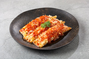 Pancakes stuffed with minced meat and topped with tomato sauce and grated cheese.