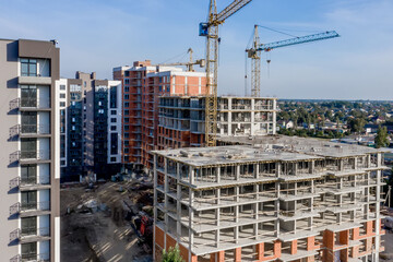 Aerial view of concrete frame of tall apartment building under construction in a city.