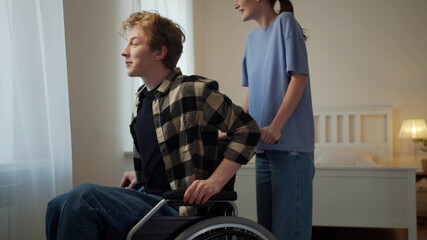 Obraz premium A woman is driving her boyfriend in a wheelchair