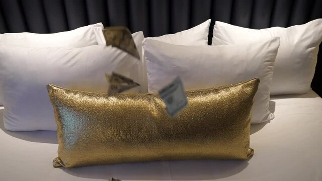 This Slow Motion Video Shows Cash Money Falling On A White And Gold Bed.