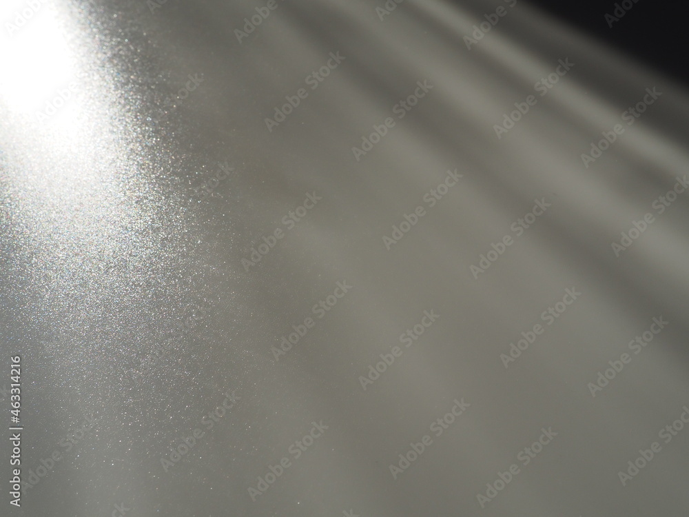 Poster abstract gray background. oblique light rays on a gray background with flickering dots. from left to