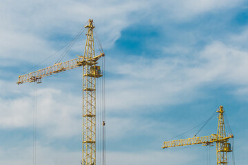 Tower industrial construction yellow crane against the blue sky