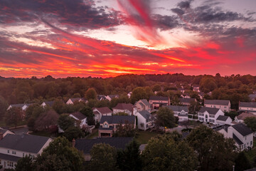 Aerial view of an American upper middle class neighborhood street with single family homes under...