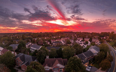 Stunning, dramatic colorful sunset streak sky over a middle class American suburban neighborhood with houses laid out close to each other on a dead end street