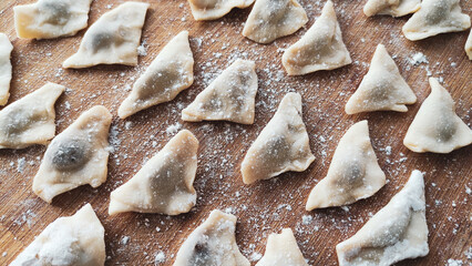 Traditional Turkish manti. Famous Turkish food manti on the wooden table. Close up of handmade manti. Traditional Turkish dumplings. Dumplings with meat onion and spice Turkish dumplings recipe