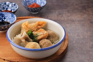 Bakso Arema, Meatballs Food Special from Malang East Java Indonesia. Close Up, on Wooden Board and Rustic Table. Served with SOy Sauce, Sauce, and Chilli Paste