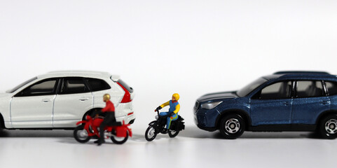 Miniature people and miniature car. A motorcycle rider who forcefully intervenes between two cars....