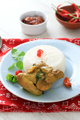 Indonesian traditional Cuisine: Ayam Woku, or Turmeric Spiced Chicken with Asian Sweet Basil, a Manadonese Chicken Dish Served with Rice