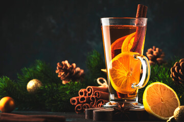Hot winter tea drink, spicy cocktail, punch or mulled wine with lemon, rum, cinnamon, anise. Rustic...