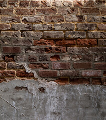 Weathered and decaying brick wall with multiple layers of concrete and tuckpointing, vertical aspect