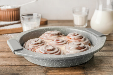 Baking dish with tasty cinnamon rolls on table