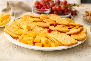 Platter with crunchy crackers and cheese on grunge background