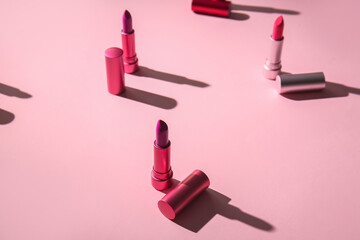 Composition with different lipsticks on color background, closeup