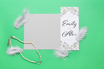 Cards with text EMILY & ALEX, feathers and necklace on green background