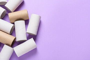 Toilet paper cardboard tubes on purple background