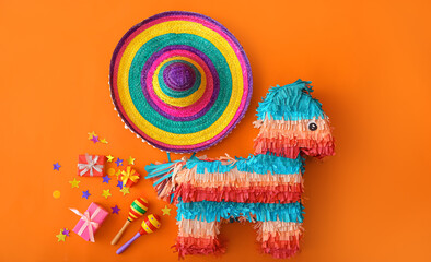 Mexican pinata with sombrero hat, maracas and gifts on color background