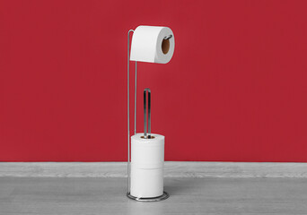 Holder with toilet paper rolls near color wall