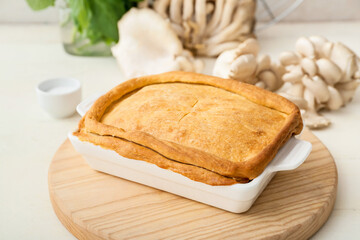 Baking dish with tasty mushroom pot pie on white wooden background