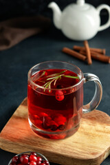 Glass cup of tasty cranberry tea on dark background