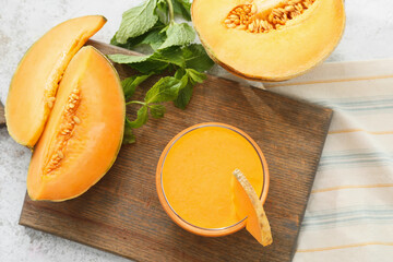 Glass of tasty melon milkshake on table
