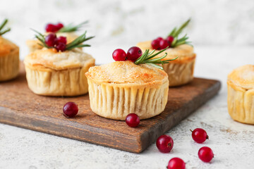 Board with tasty mince pies on light background, closeup