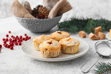 Plate with tasty mince pies on grey background