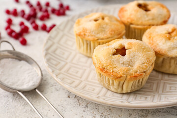 Plate with tasty mince pies on grey background, closeup