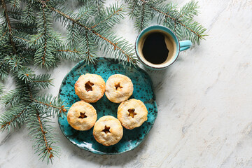 Plate with tasty mince pies and cup of coffee on light background