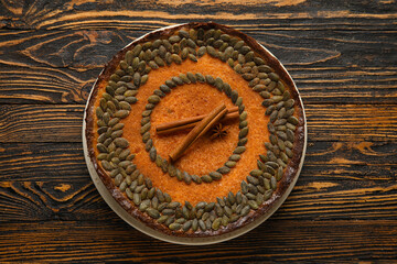 Fototapeta na wymiar Delicious pumpkin pie with cinnamon on wooden background