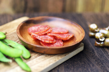 小皿に盛られたサラミと枝豆のおつまみ