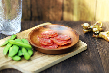 小皿に盛られたサラミと枝豆のおつまみ