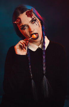 woman with scary halloween makeup with bloody horns dark background