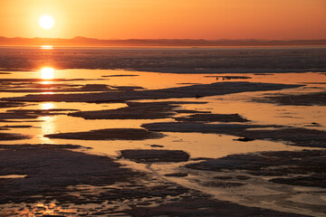 氷が浮かぶ夕暮れの光る湖
