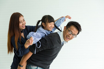 Happy Asian family having fun with home. Asian father playing and carrying little daughter on back at home with happy and smile