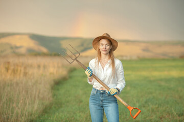 Country woman in field with pitchfork. Harvest festival