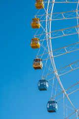 Close view of a ferris wheel, under blue sky.