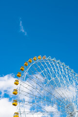 Close view of a ferris wheel, under blue sky.