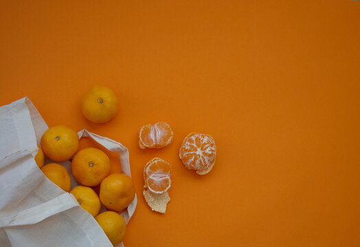 Directly Above Shot Of Tangerines In Textile Bag Against Orange Background