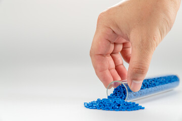 Hand holding plastic tube. polymer pallet. plastic beads. wax pallet.