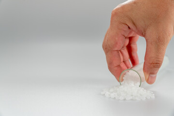 Hand holding plastic tube. polymer pallet. plastic beads. wax pallet.