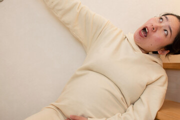 A young pregnant Asian woman slips on the stairs in a house