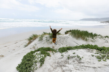 young boy exploring rocky coastline, Grotto Beach, Hermanus, South Africa