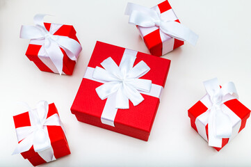 Five red gift boxes with ribbons on a white table, Christmas.