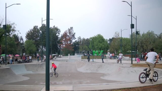 Peaceful view of young people riding BMX bicycles in skatepark