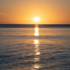 Beautiful sunrise over Pentewan Sands in Cornwall with pastel sky and long exposure ocean