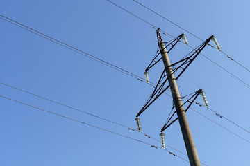 Power line distribution pole against the blue sky.